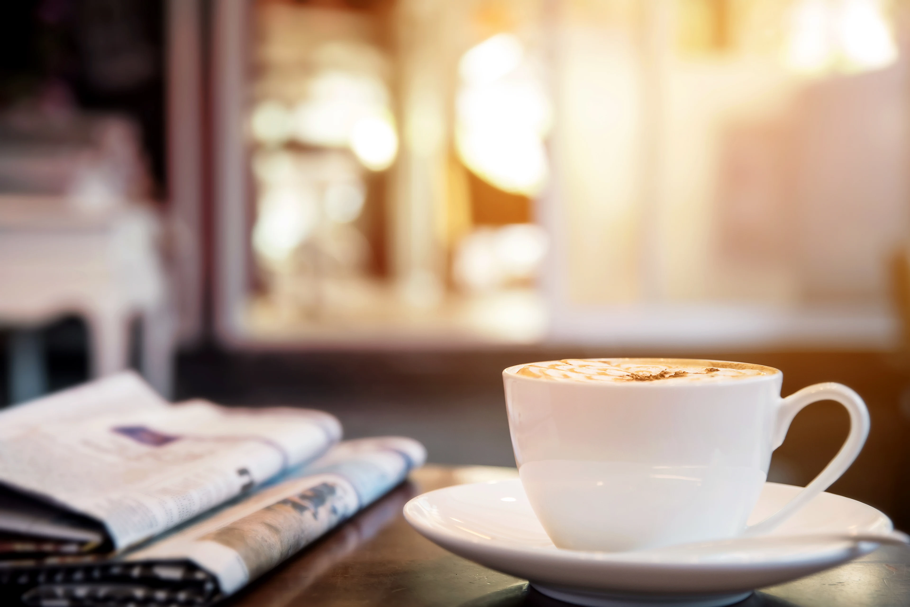 En koppe kaffe och en papperstidning i loungen på Kastrup