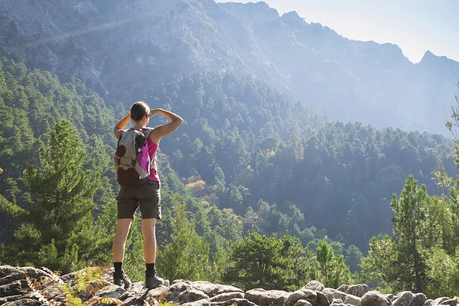 een dame kijkt tijdens een wandeltocht uit over de vallei