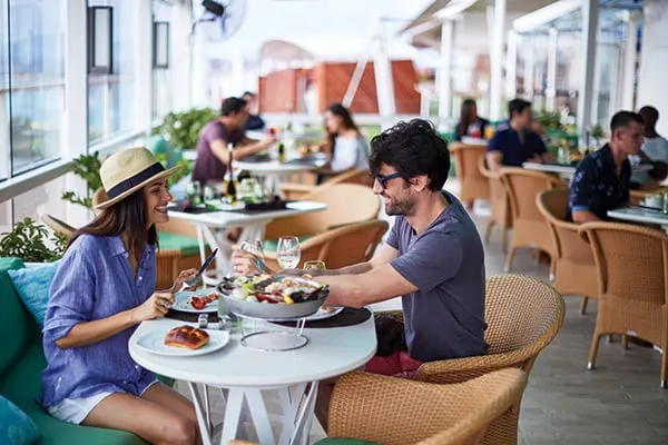 Ett par som sitter vid ett bord i en restaurang med flera olika maträtter på bordet