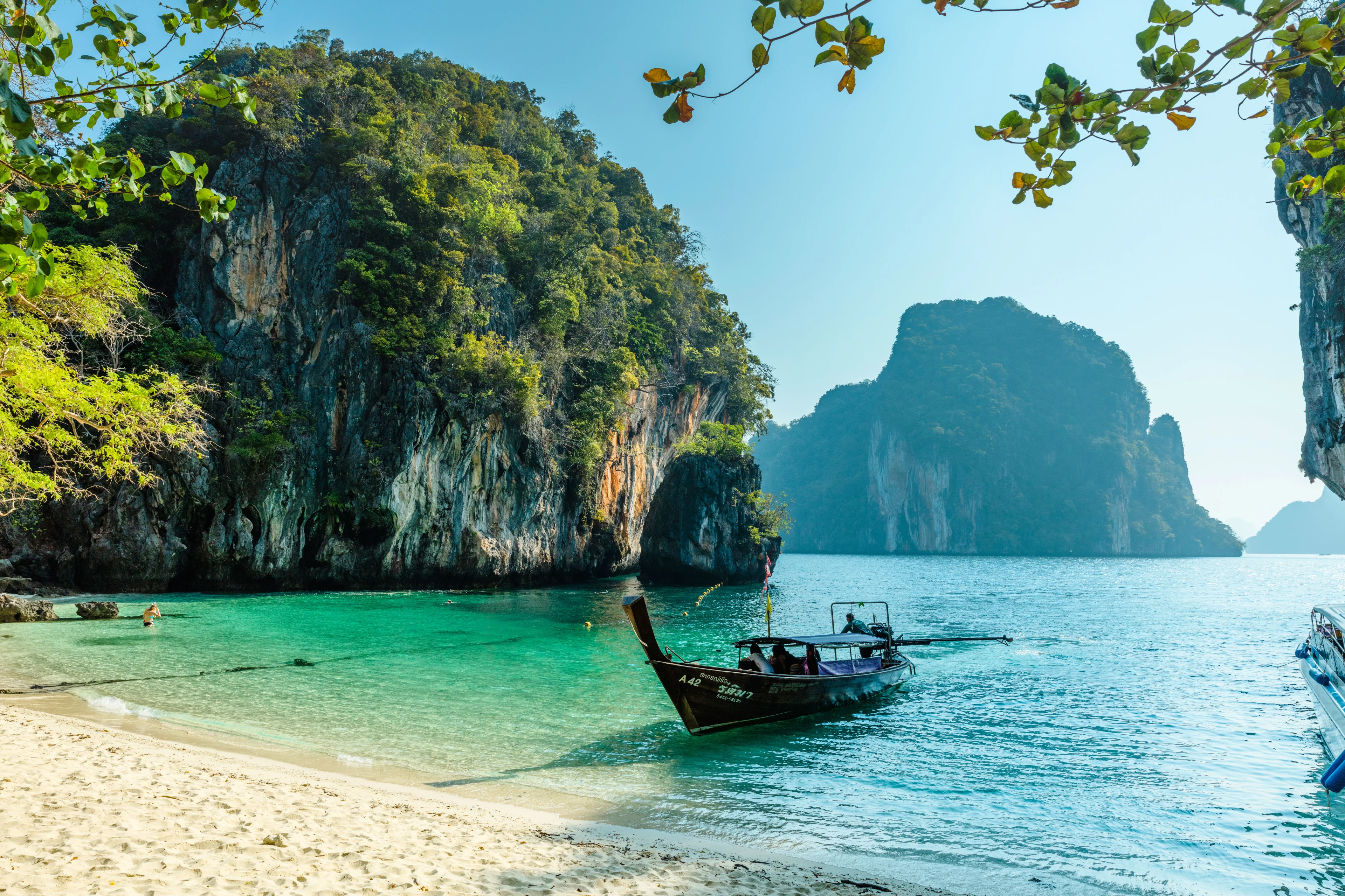 Strand i Thailand med to båter på kysten 