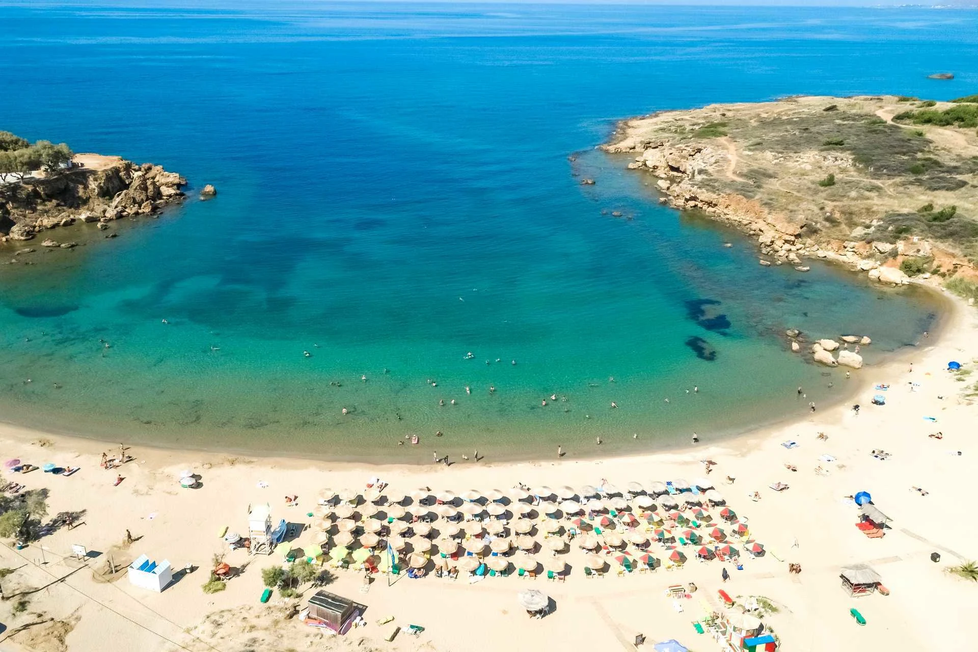 fugleperspektiv over den herlige stranda i Agii Apostoli med solsenger og parasoller