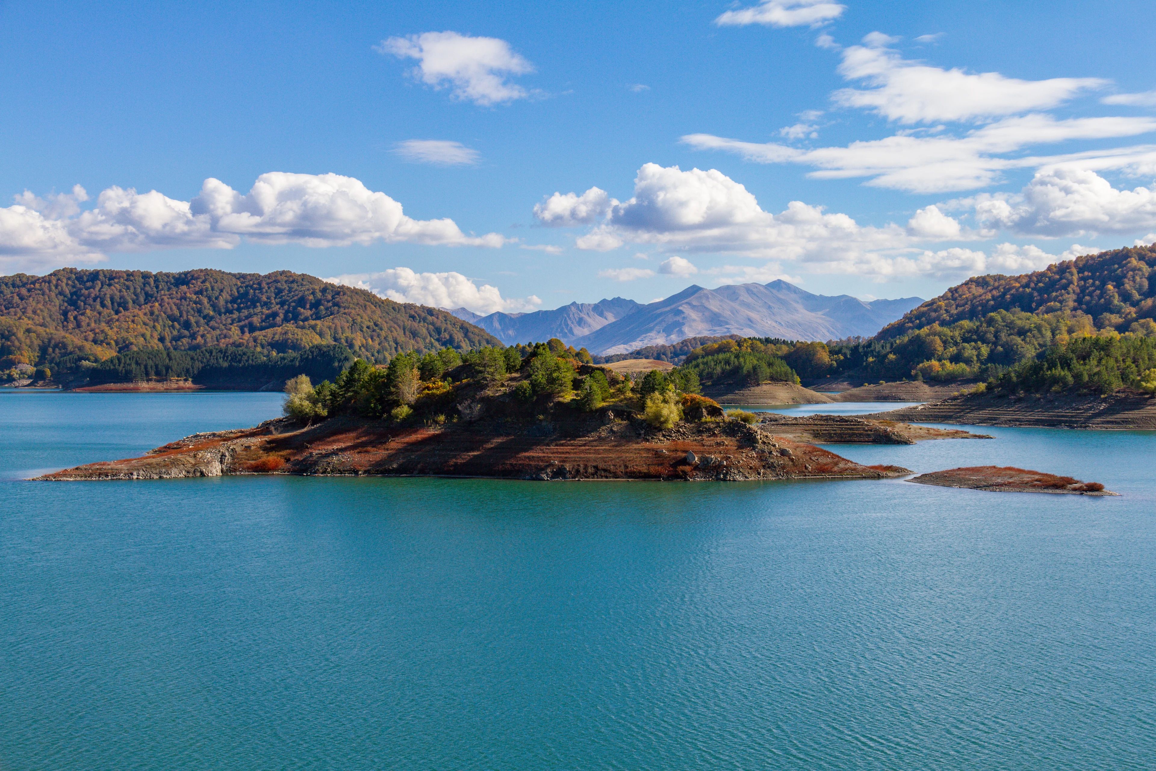 Aoossjön nära Metsovo i Epirus, omgiven av skogsklädda berg och små öar.