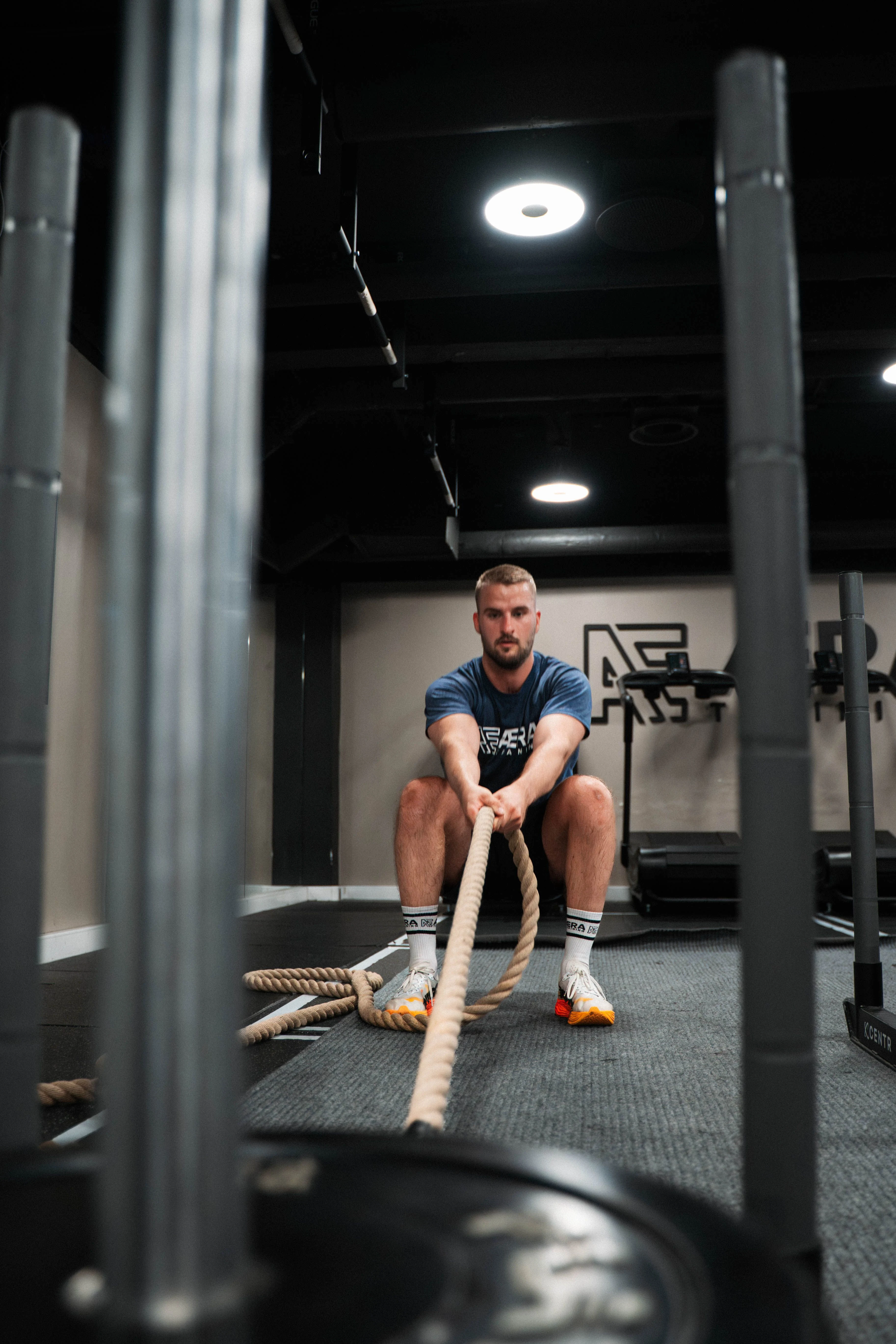 En mann som trekker i et tau som er festet i en vogn med vekter