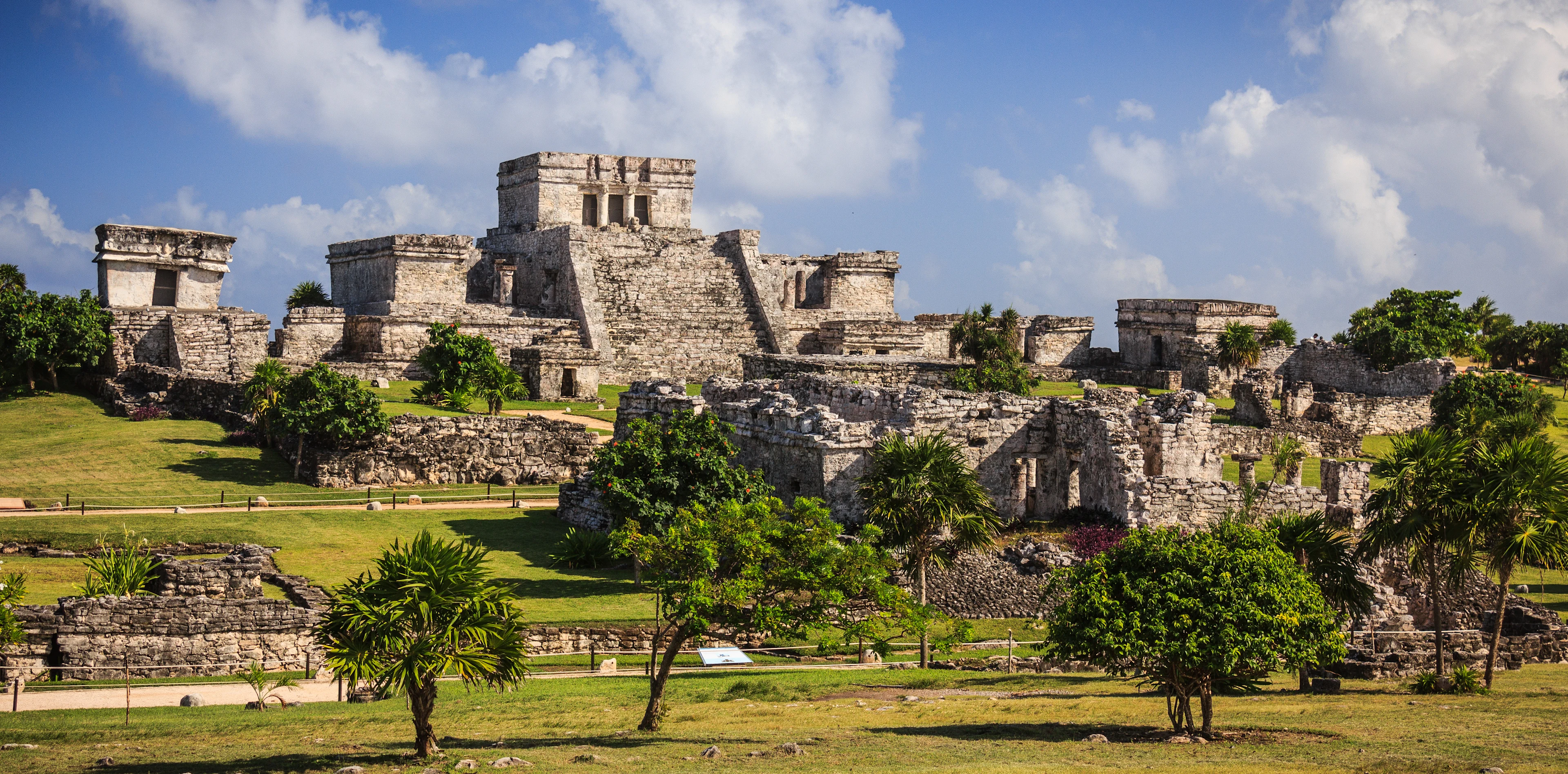 Mayaruinerna i Tulum med gamla stenbyggnader och tempel omgivna av grönska.