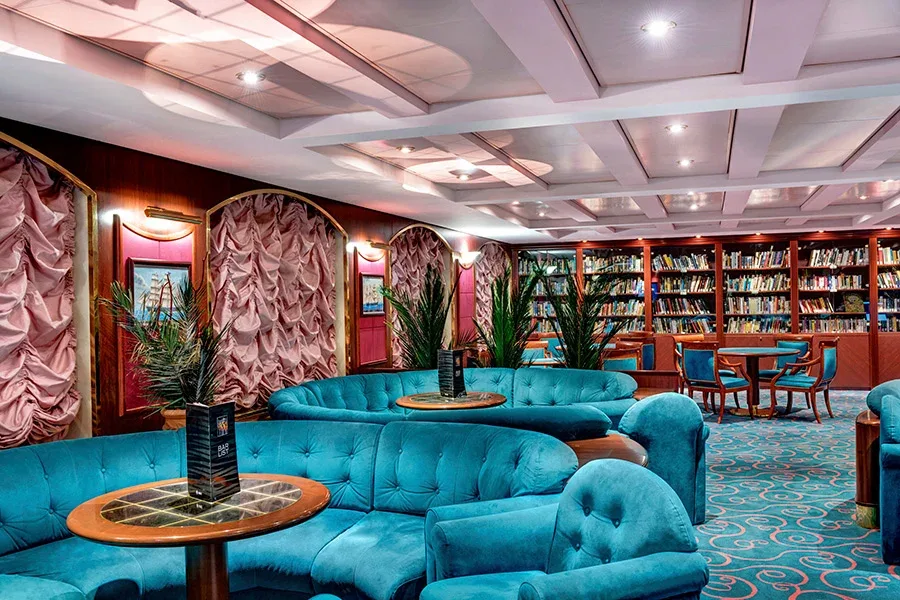 Bar med röd blåa inredningsdetaljer med långa bokhyllor