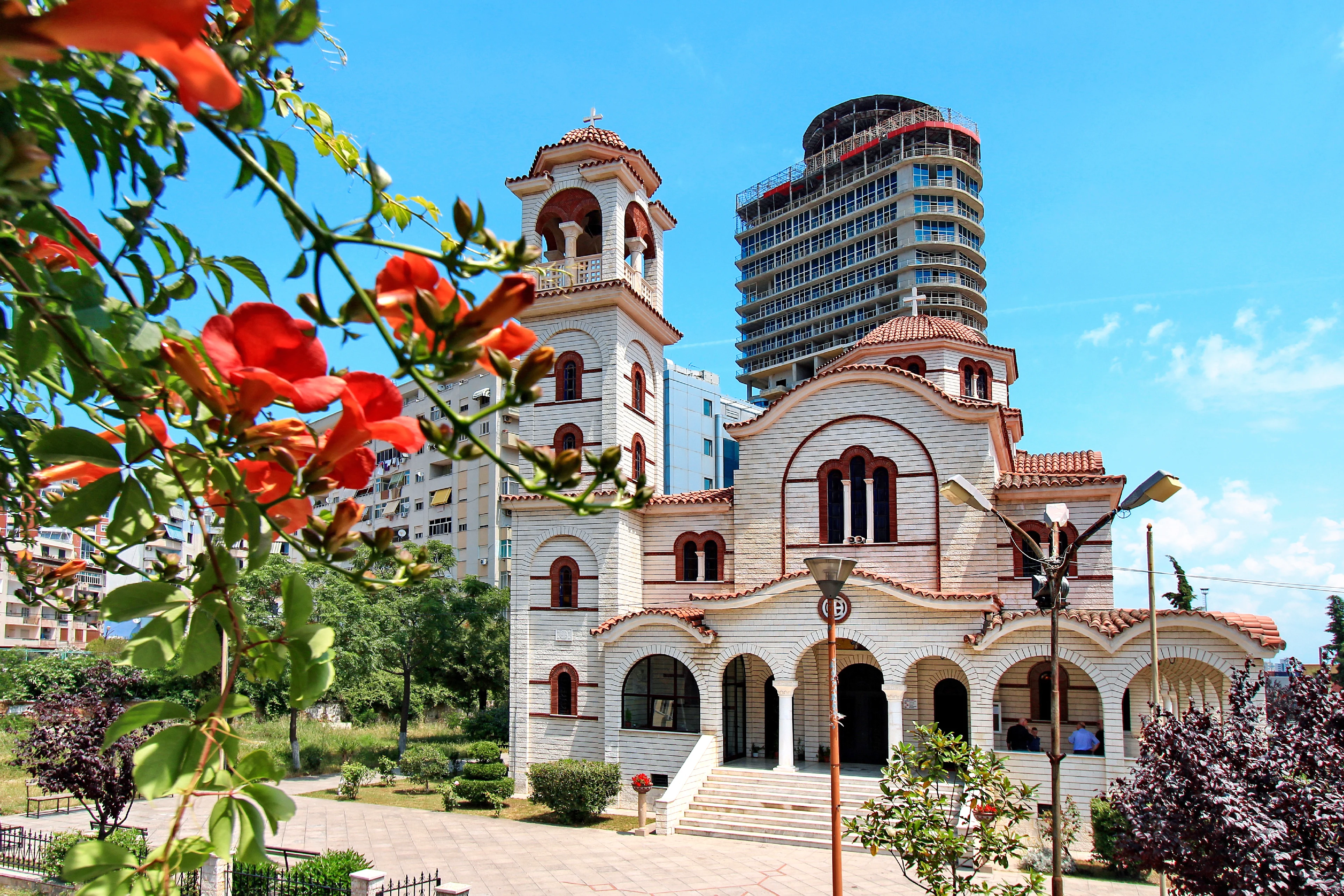 Mindre kyrka i Durres med röda blommor i förgrunden