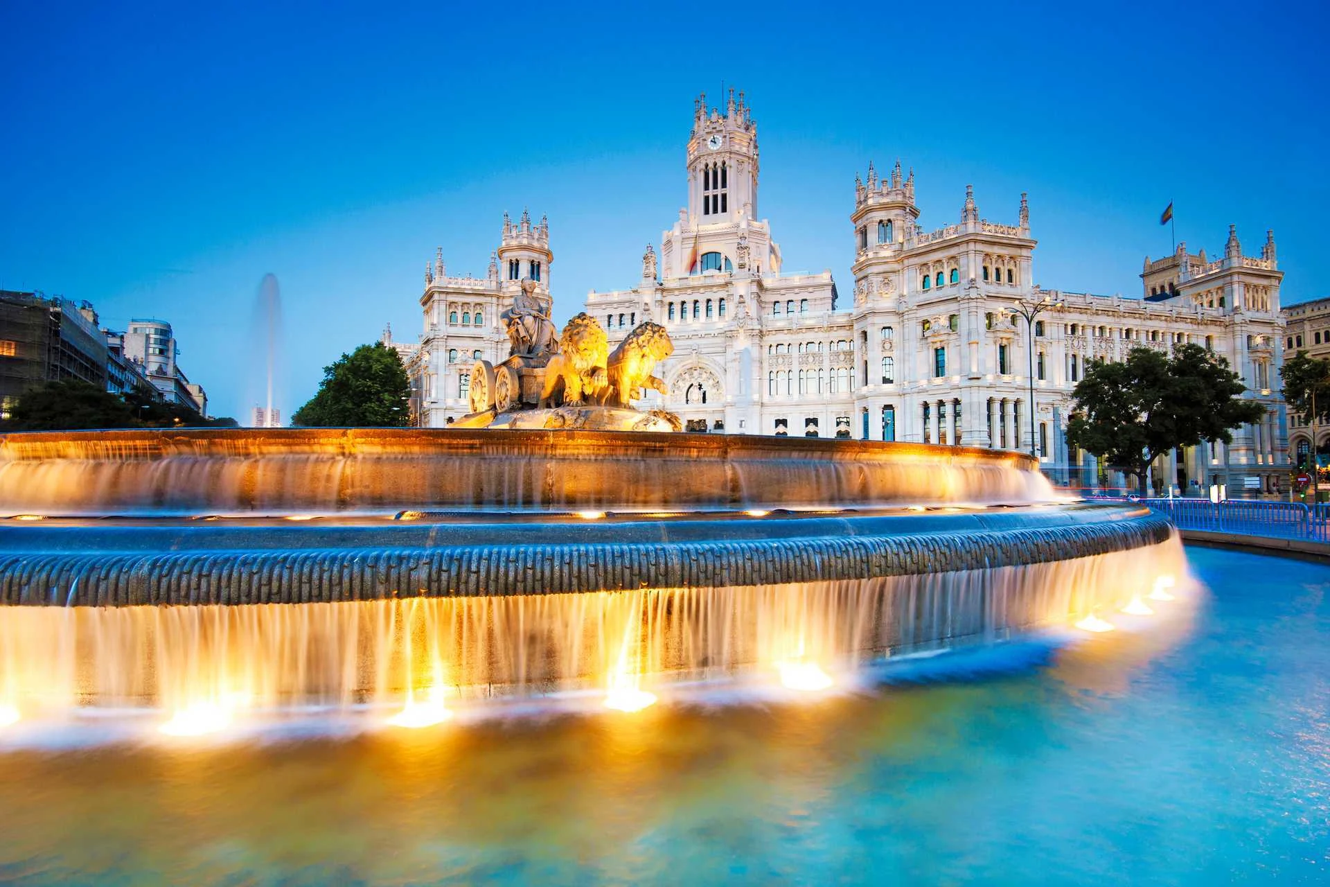 Fuente de Cibeles og Palacio de Cibeles i Madrid, oplyst i skumringen.