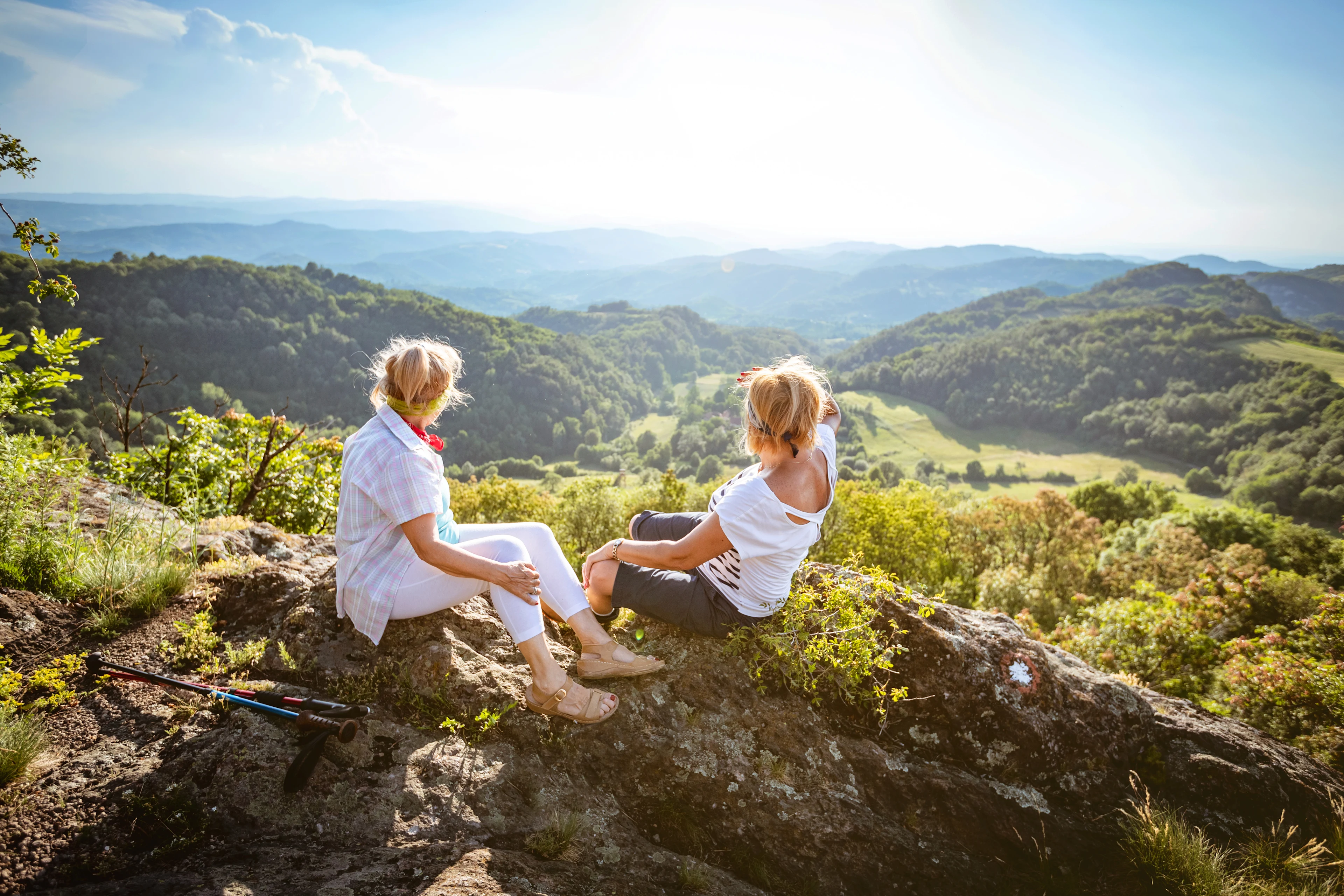 Två kvinnor sitter och ser utöver bergen