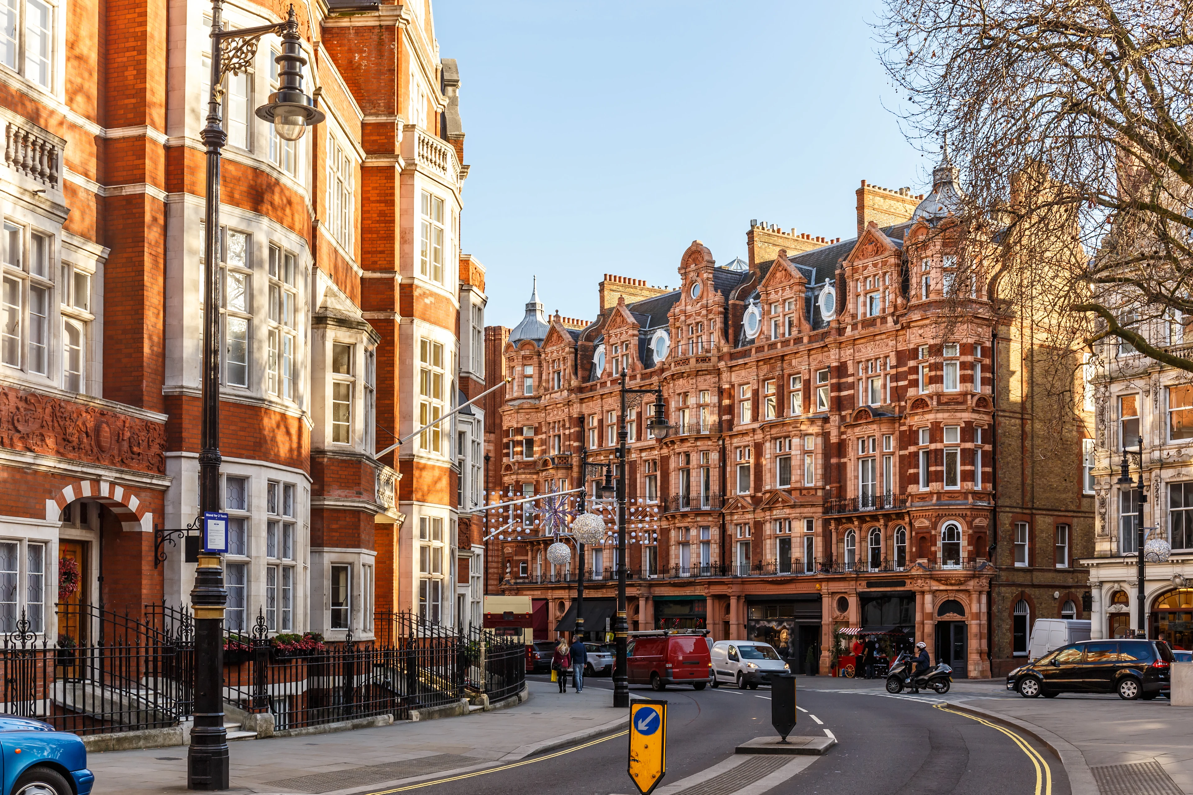 Historiska tegelbyggnader och klassisk Londonarkitektur längs en lugn gata i stadsdelen Mayfair.