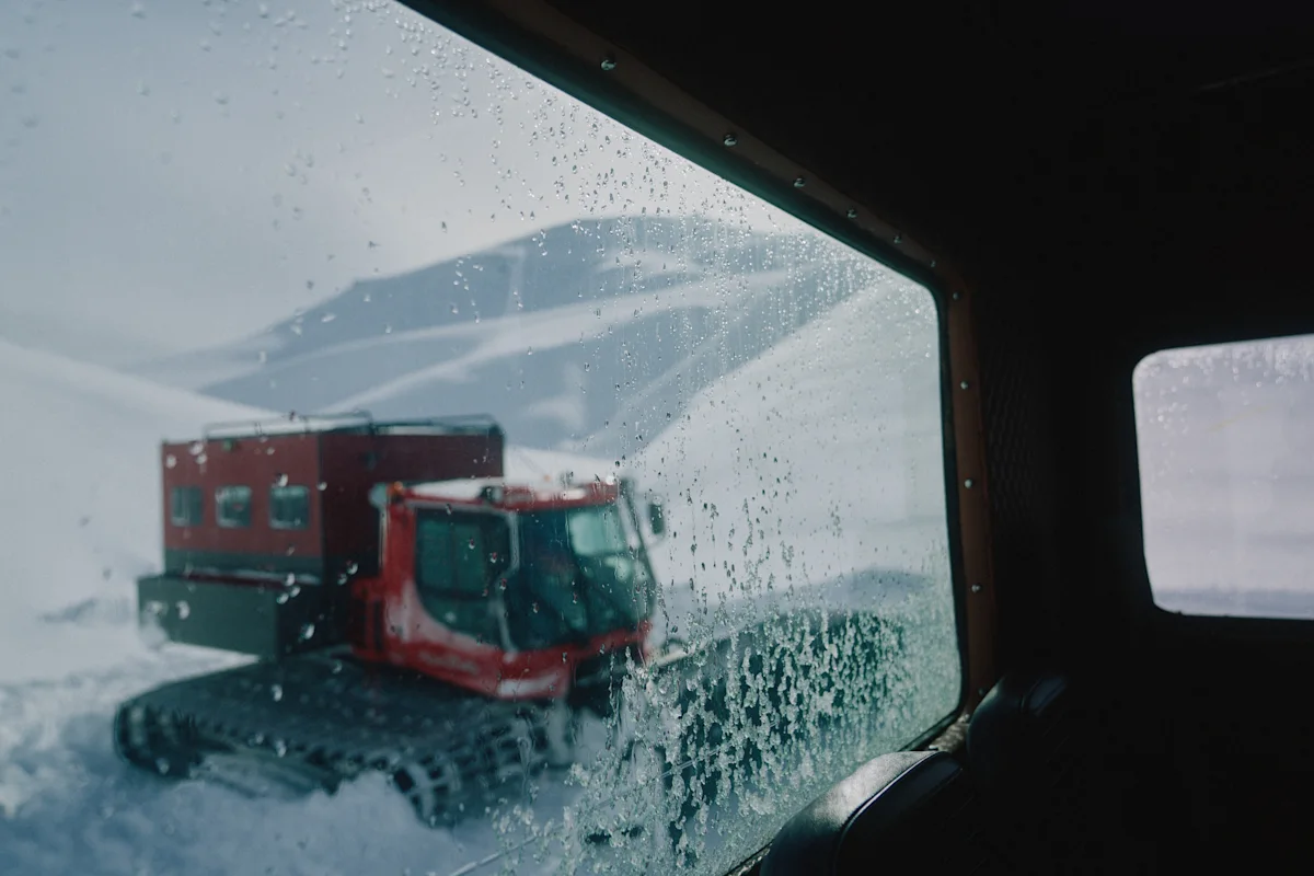 Snowcat sett gjennom et frostet vindu i et vinterlandskap