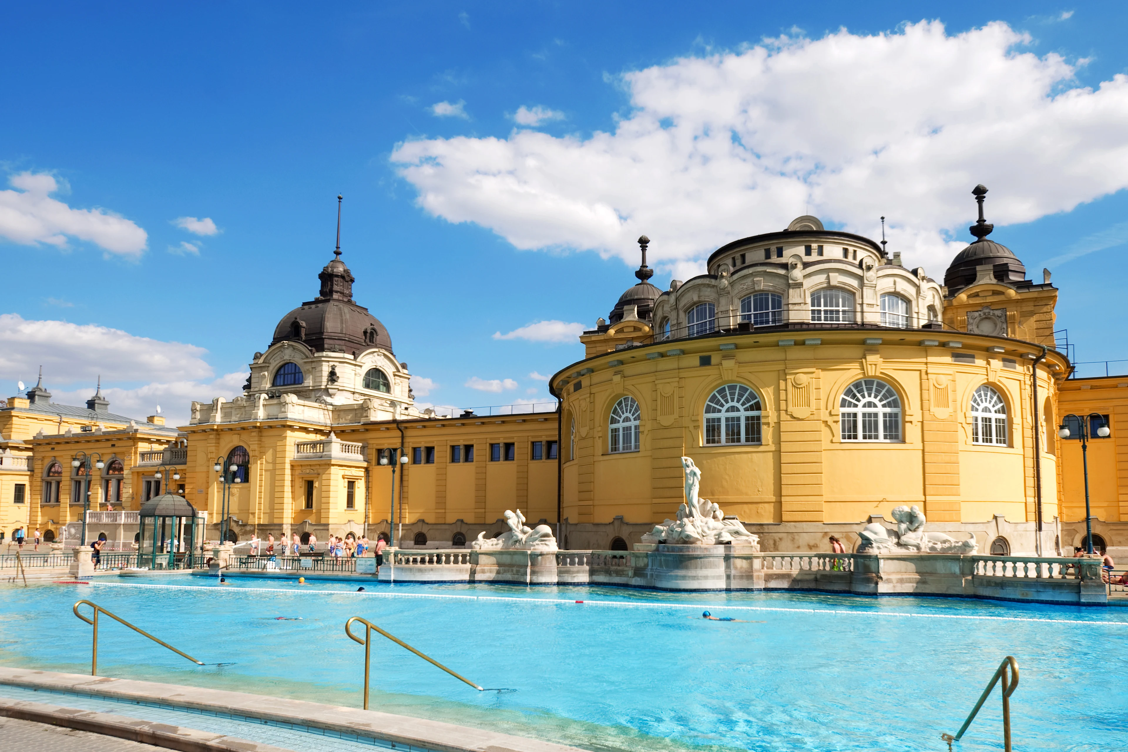 Széchenyibadet i Budapest med sina utomhuspooler och den gula byggnaden i bakgrunden