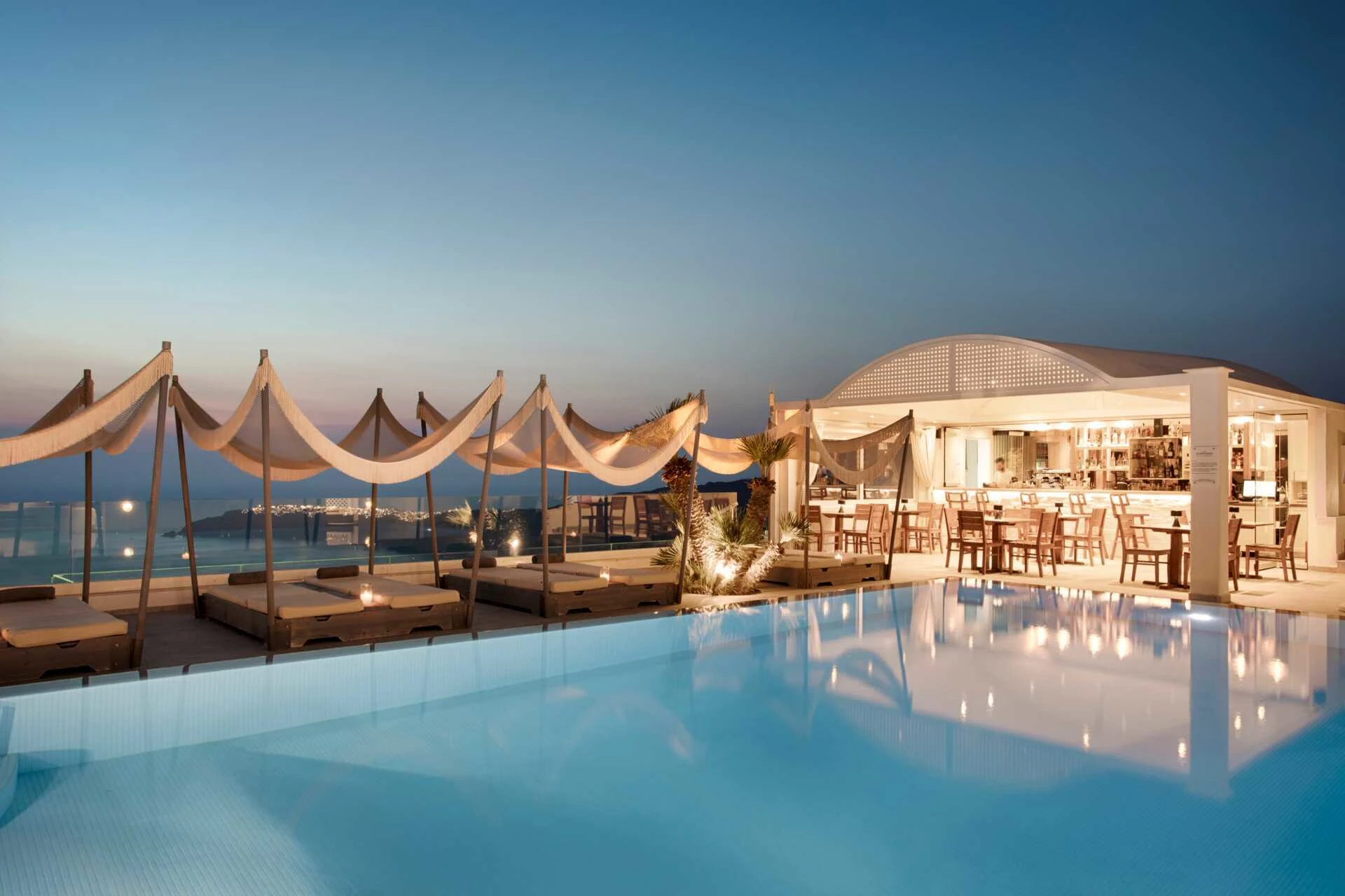 Kveldsbilde fra Andromeda Villas & Spa Resort med basseng, bar og fantastisk utsikt utover havet