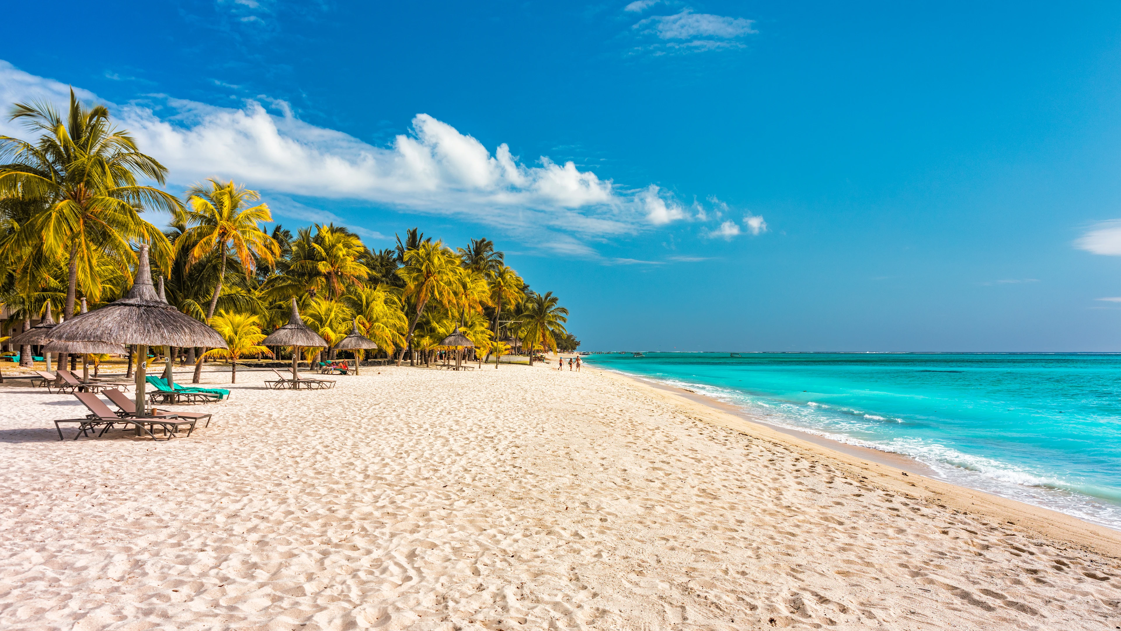 Strand på Mauritius med kristallklart vatten, palmer och vit sand vid Indiska oceanen.