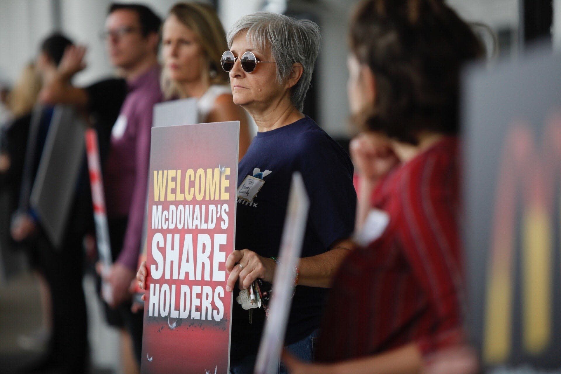 shareholder-shakeup-woman-holding-sign-protest-line-dallas