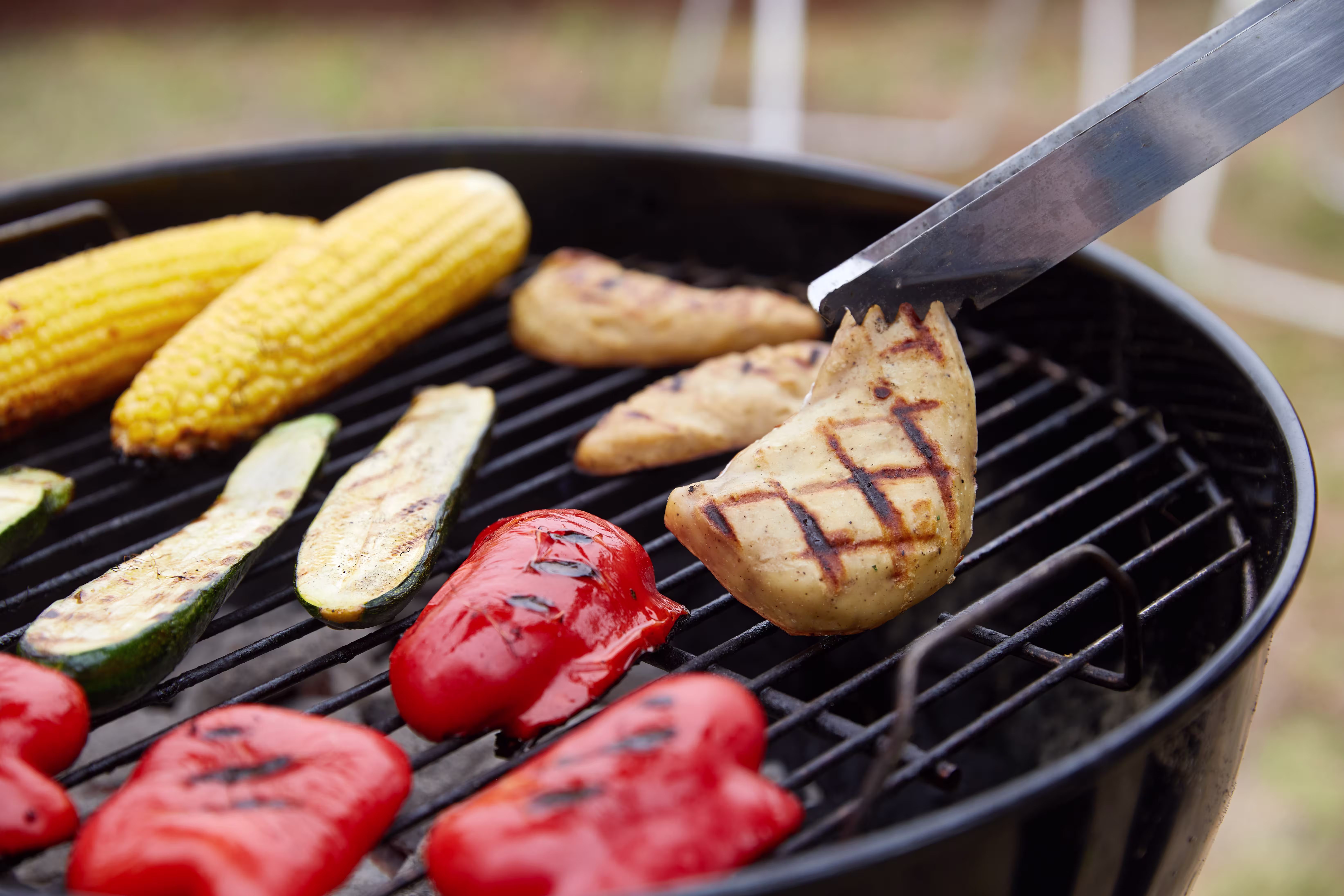 Cultured chicken on a grill with vegetables.