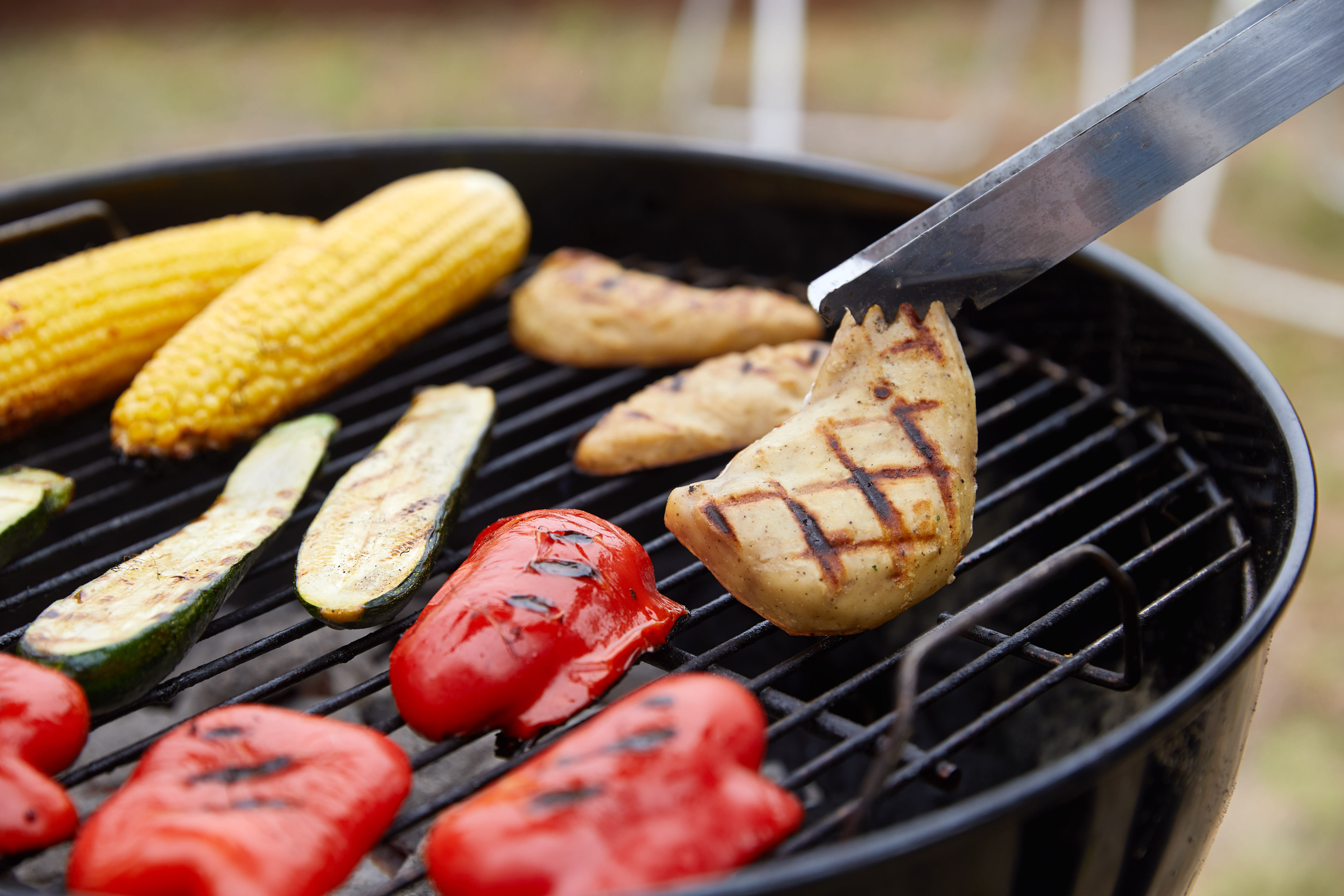 Cultured chicken on a grill with vegetables.
