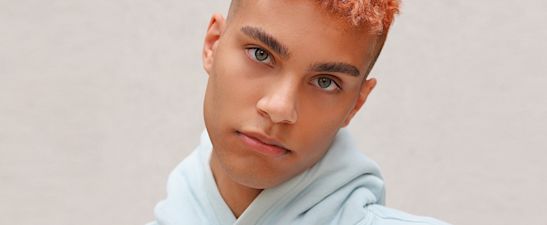 A young man with bright hair in hoodies