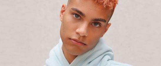 A young man with bright hair in hoodies