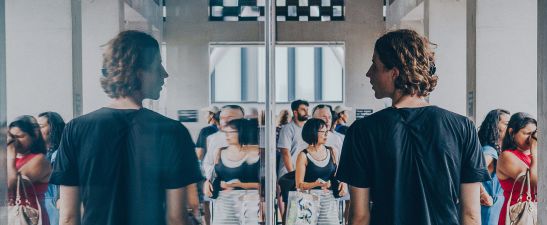 A person and their reflection in a glass pane