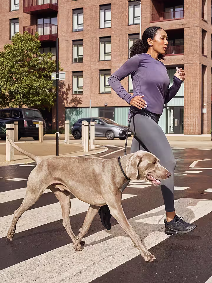 A person running with a dog in the city