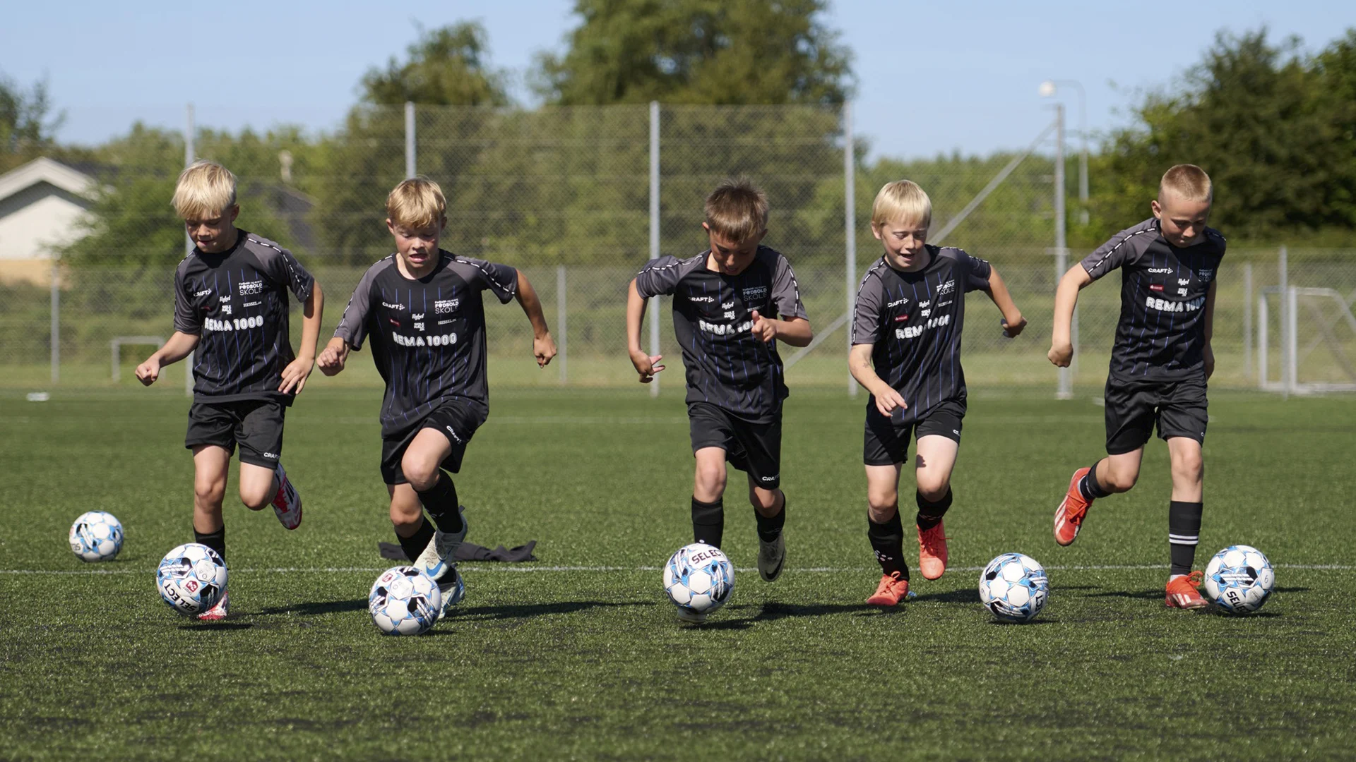 Billede - Stolt samarbejdspartner - fem drenge spiller fodbold