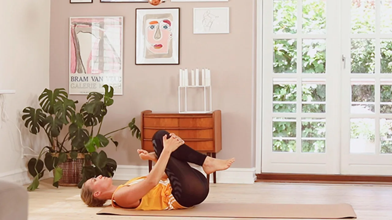 Julie Bruun Yoga ligger på ryggen