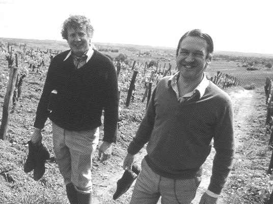 Tony and Will walking through a vineyard 