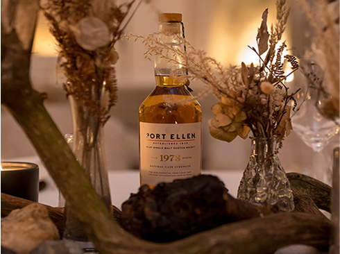 A bottle of Port Ellen hidden within decorative wooden and floral pieces