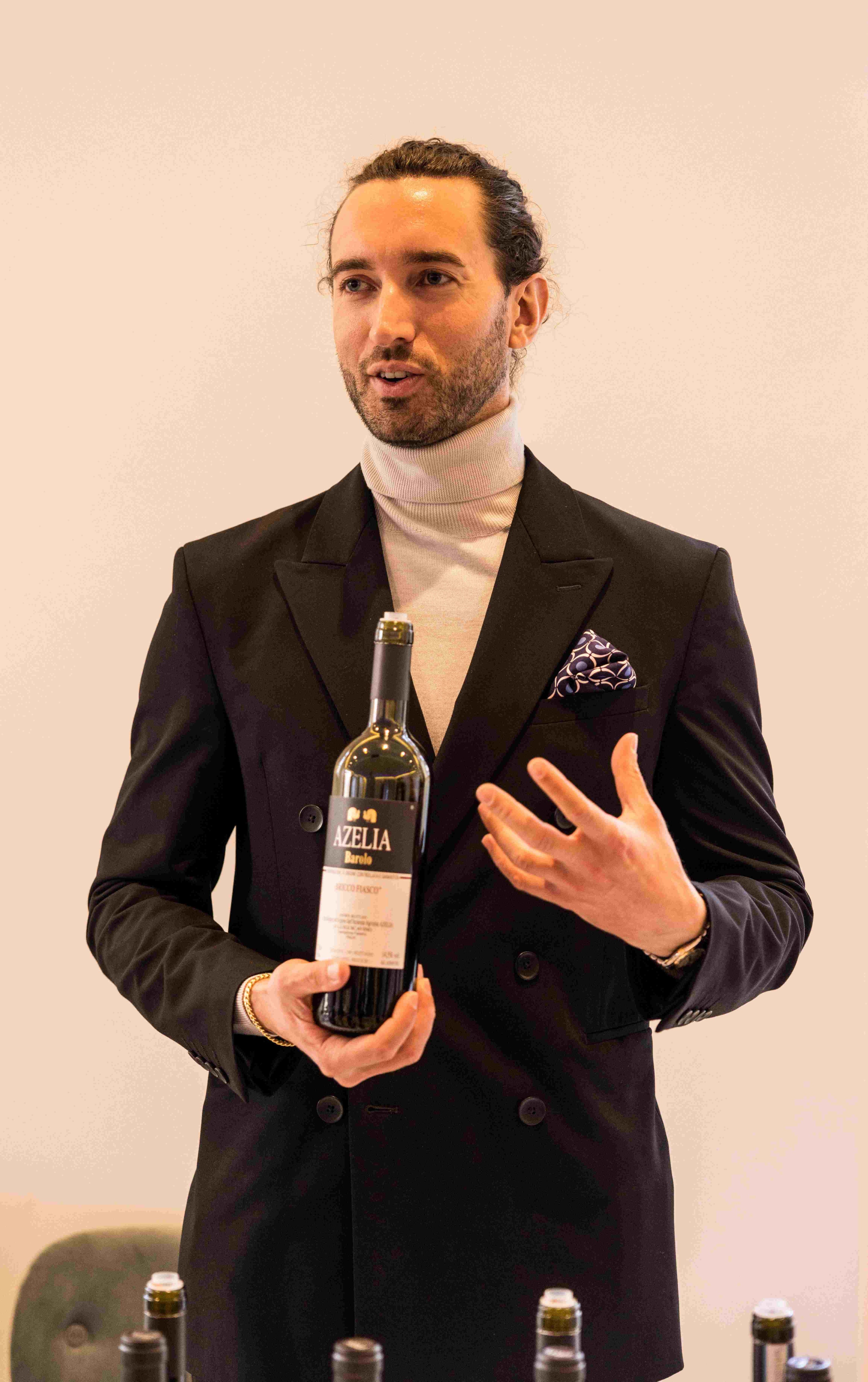 man in suit holding wine