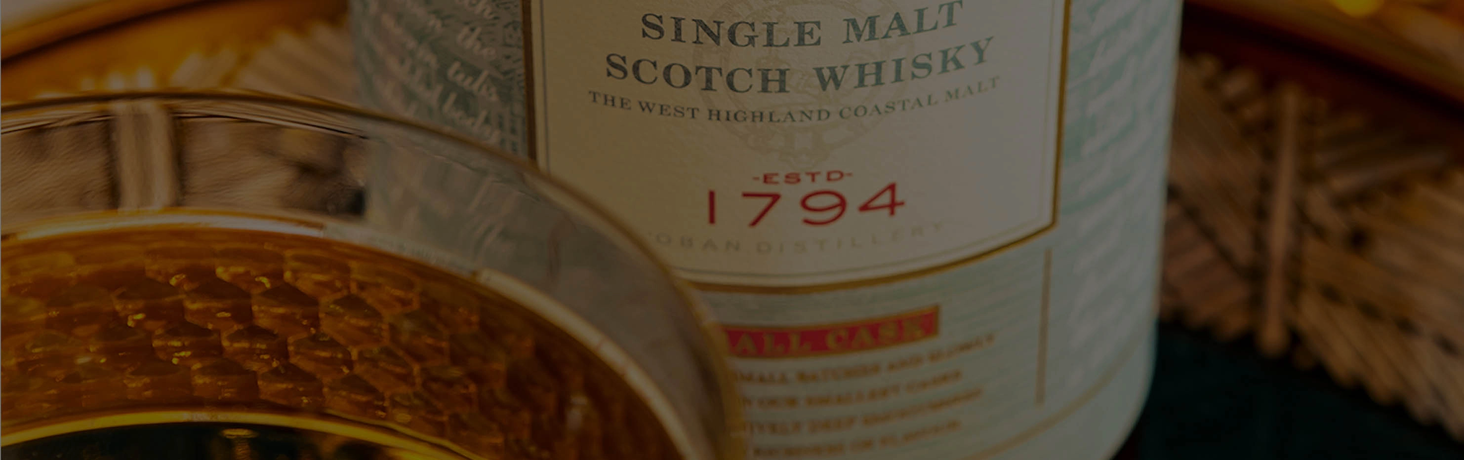 glass of whiskey on top of a barrel