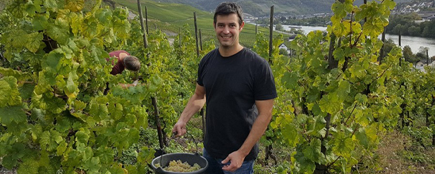 man smiling at camera in a vineyard