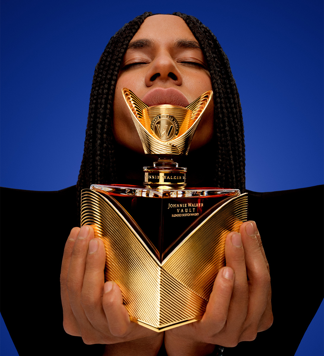 Olivier Rousteing holding a Couture Expression: Fall bottle while closing their eyes and holding the bottle upwards