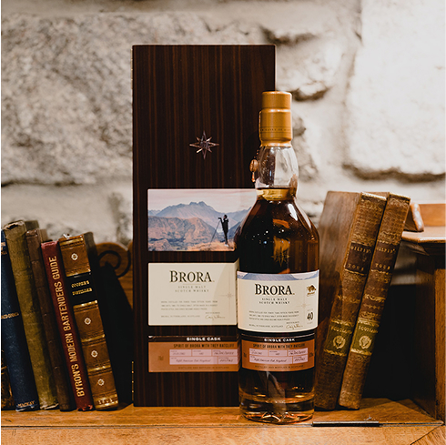 A bottle of Brora Cask of Distinction beside a row of books