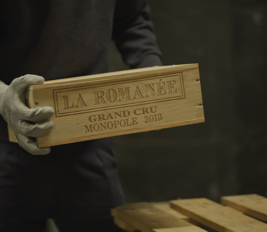 A person holding a La Romanee box in storage in Justerini & Brooks