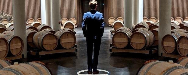 Man standing, surrounded by barrels