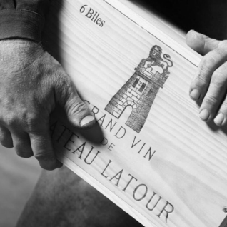 black and white image of hands holding a lined sheet of paper with a drawing of a building on it