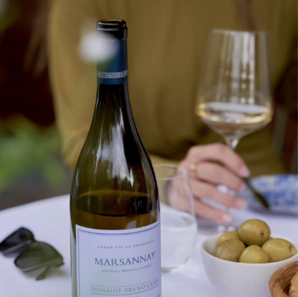 woman sitting on table with a glass of white wine