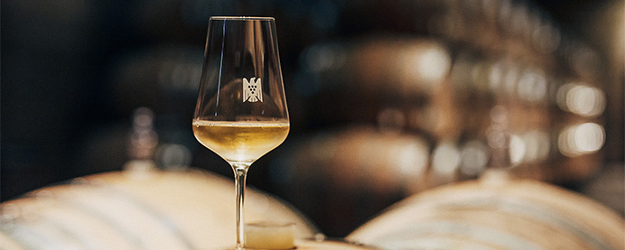 Person reviewing a wine and writing notes