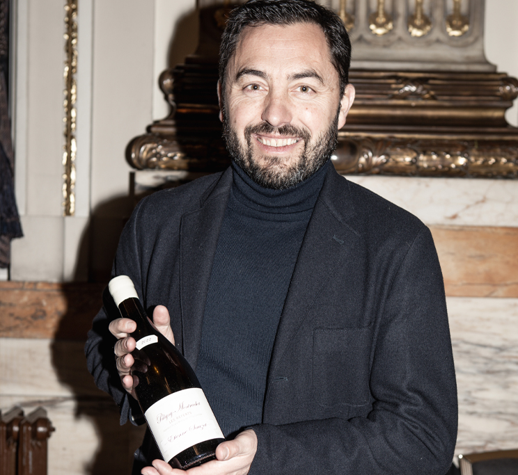 A man holding up a wine bottle, Etienne Sauzet