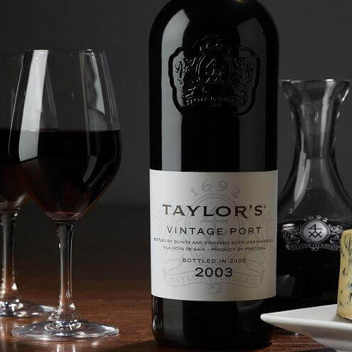 Glass of port next to a bottle