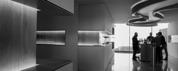 Black and white people around a bar in front of a large, wall sized window