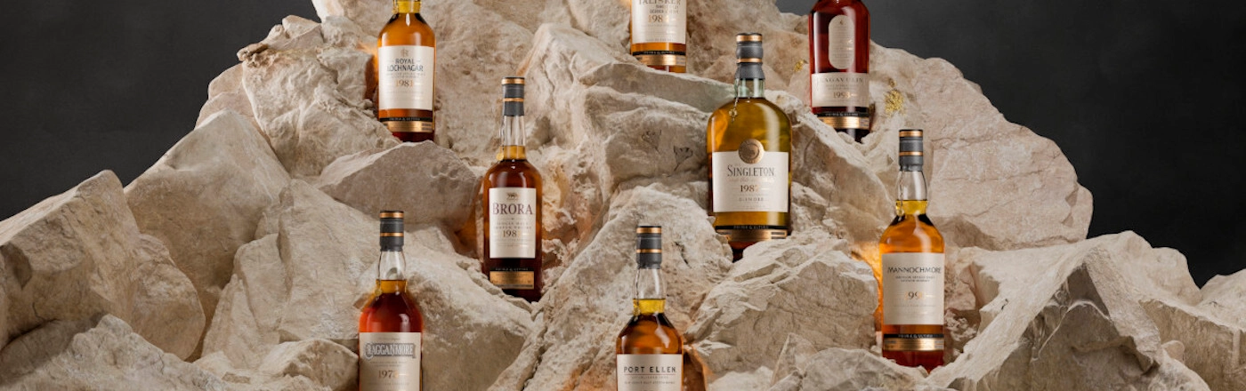 Image of 8 whisky bottles displayed on a rock