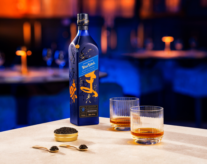 Bottle on table with two glasses and bowl of caviar