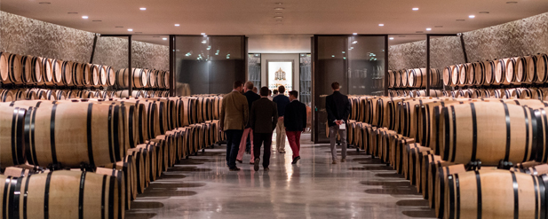 men walkint through room full with barrels