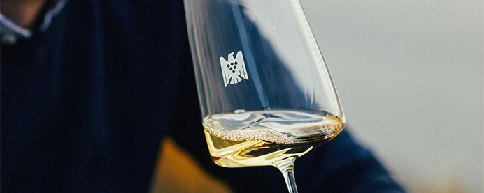 Person reviewing a wine and writing notes