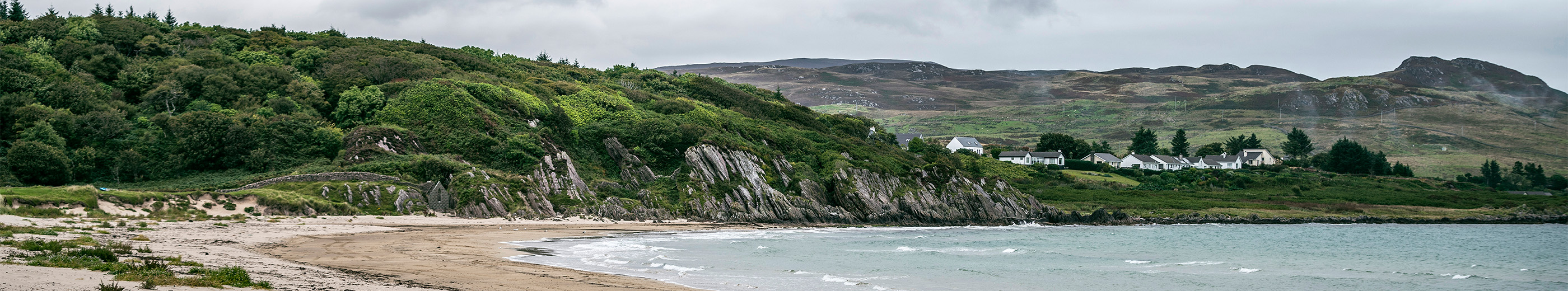 A beach with mountains on the horizon in the Isle of Islay