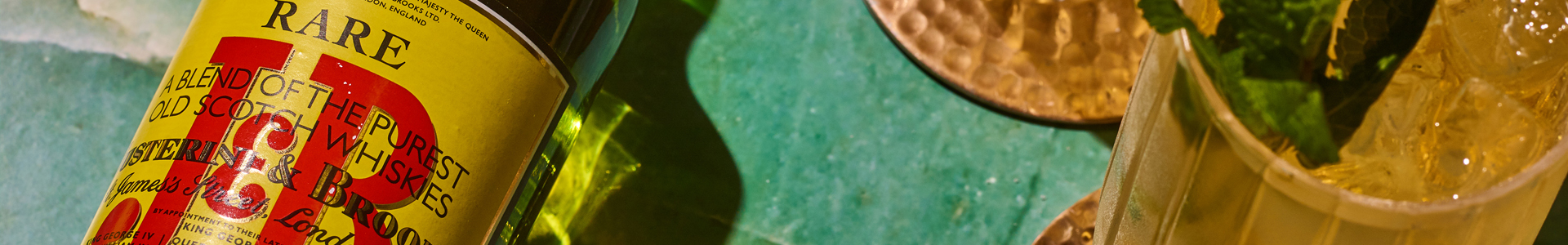 close up of J&B rare bottle on teal background