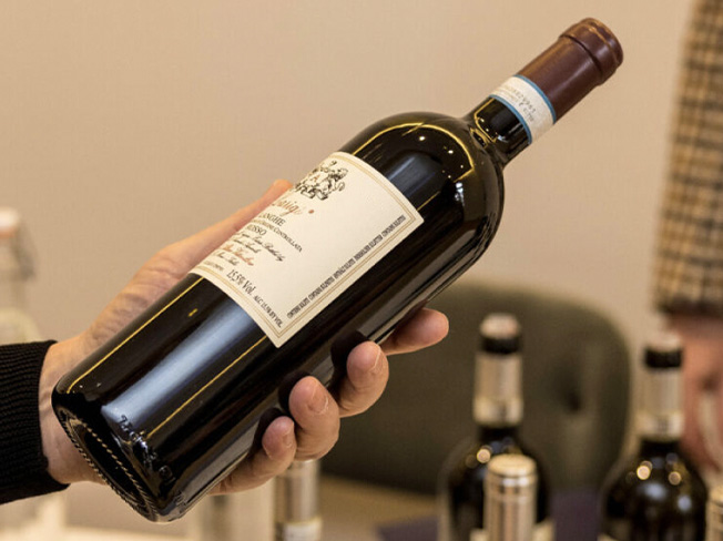 A person holding a bottle of wine