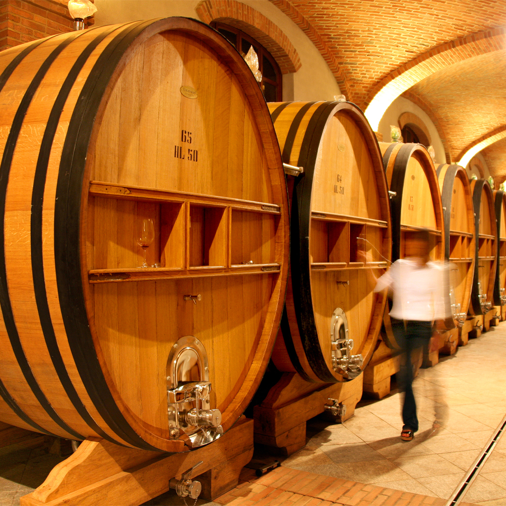 man standing against a case of wine bottles