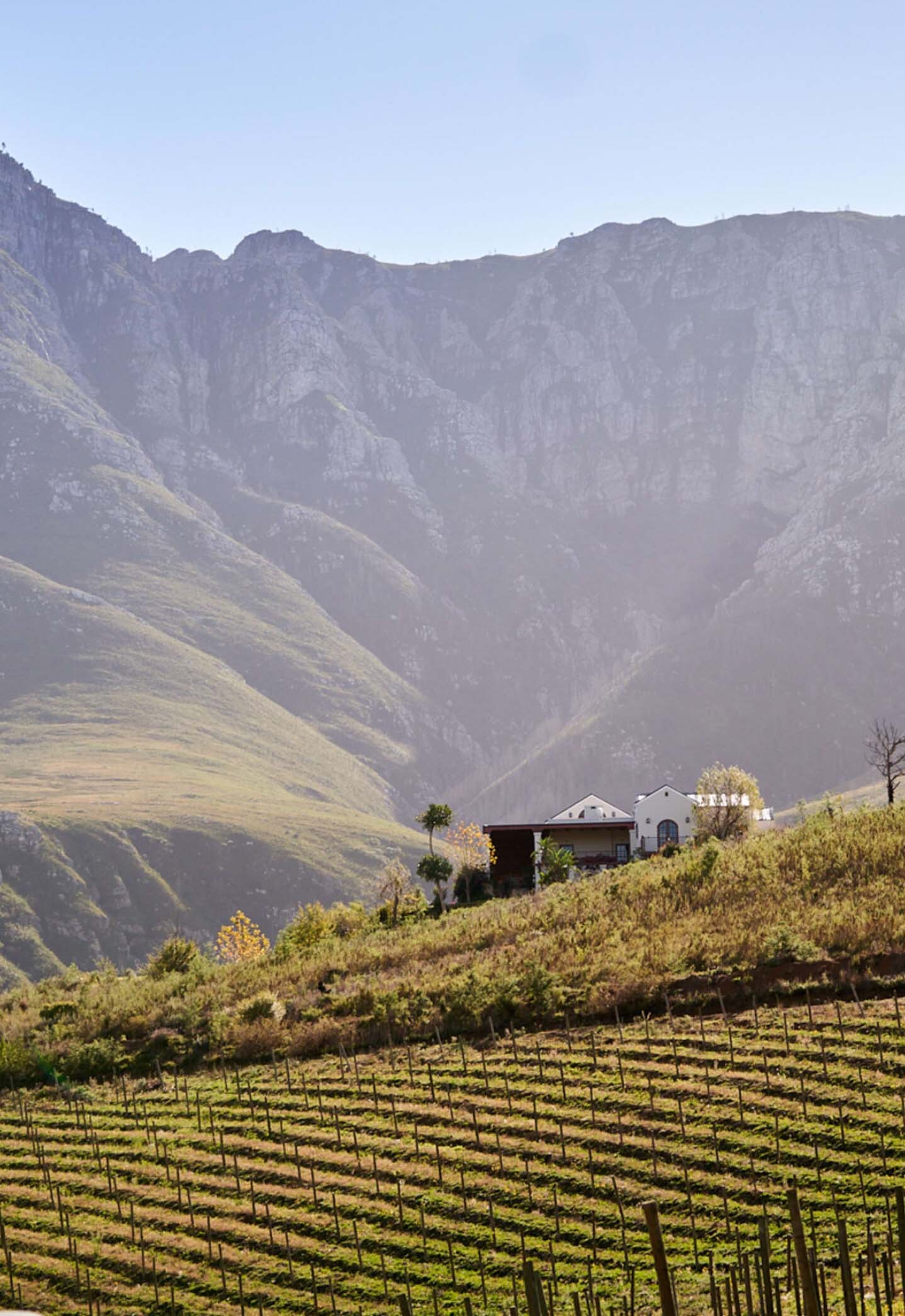 mountainscape with rolling hills and a white house